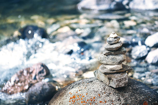 istock Stone pyramid cairn near river, buddhism 610157122