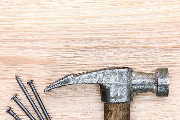 istock wooden board background with nails and old hammer on it 610157452