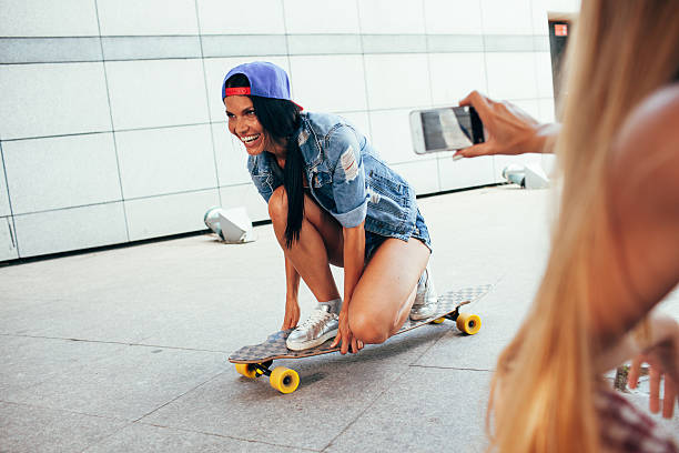 istock one woman shooting other on longboard 610158248