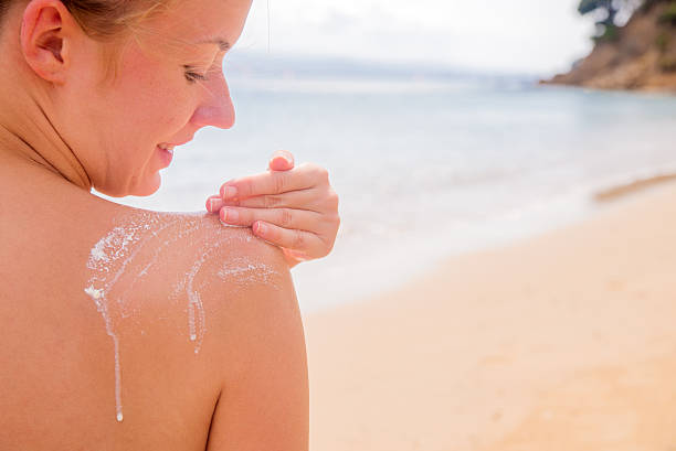 istock Woman applying Suntan Lotion at the beach 610158302