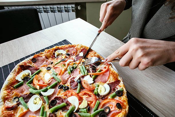 istock Slicing fresh pizza with pepperoni and vegetables 610161414