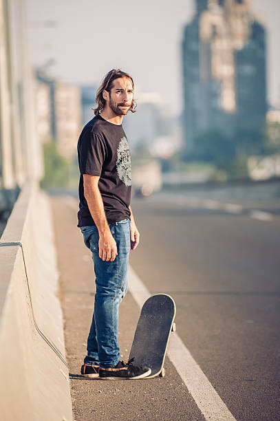 istock Skateboarder standing on the city road bridge 610161948