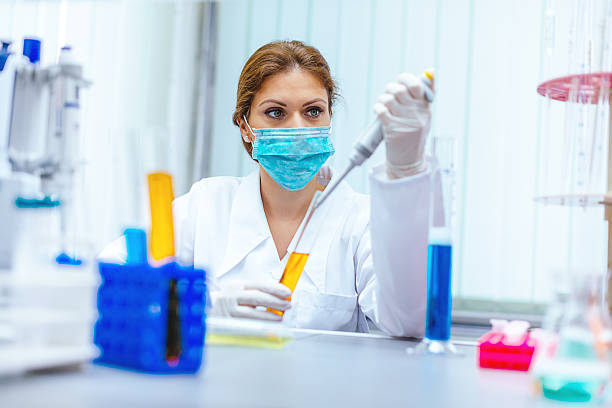 istock Acid and base solutions examined by female scientist in laboratory 610162152