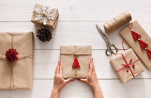 istock Woman's hands wrapping christmas holiday present with craft twine 610217174