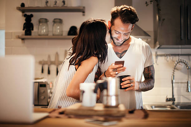 istock Young couple at home using smartphone - Morning breakfast time 610217732