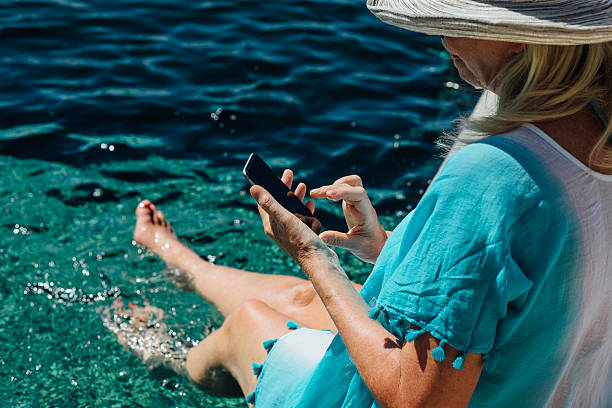 smartphone a bordo piscina - women wading sun hat summer foto e immagini stock