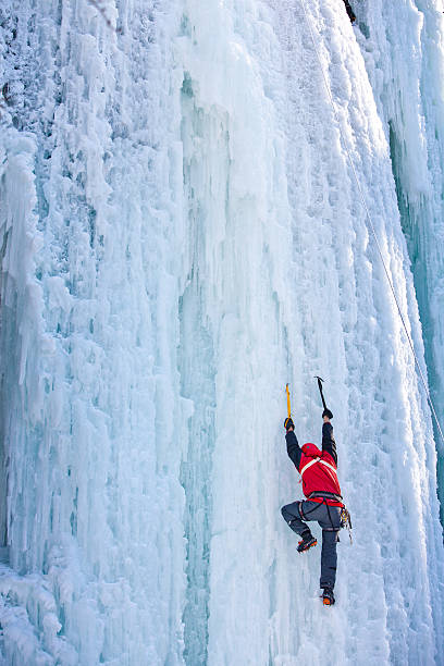 istock Man climbing frozen waterfall 610219344