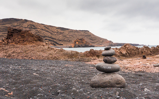 Stones piled on a  beach at El Golfo in a cloudy day
