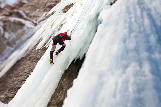istock Man climbing frozen waterfall 610220242