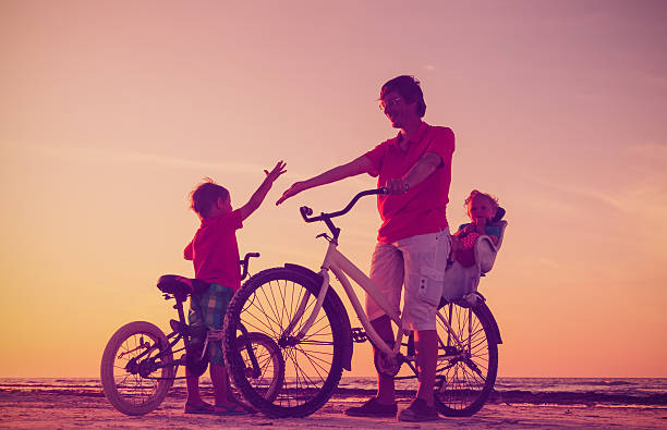 istock silhouette of father with two kids on bikes 610222500