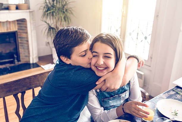 istock french boy embracing his sister at breakfast table 610222606