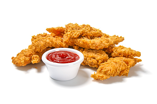 Fried Breaded chicken tender strips with french fries and tomato ketchup on a plate. Dark backgrund. Top view.