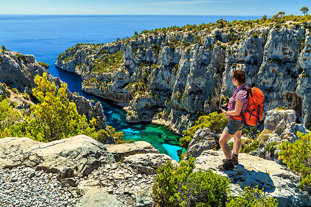 Famous Calanques D'En Vau in Cassis near Marseille,France Young hiker woman with backpack and photo camera on the high cliffs,Calanques D'En Vau bay,Calanques National Park near Cassis fishing village,Provence,South France,Europe bouches du rhone photos stock pictures, royalty-free photos & images