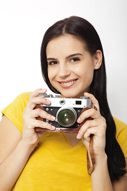 istock Young Woman Holding retrocamera against white background 610229090