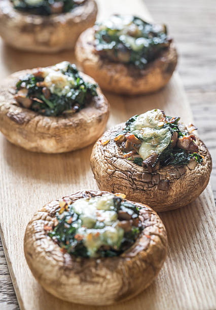 Baked mushrooms stuffed with spinach and cheese Baked mushrooms stuffed with spinach and cheese stuffed stock pictures, royalty-free photos & images