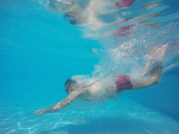 istock Beard man with glasses diving in a pool 610231332