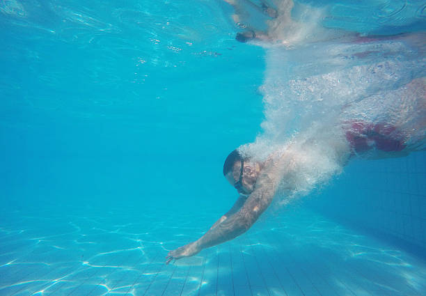 istock Beard man with glasses diving in a pool 610231386