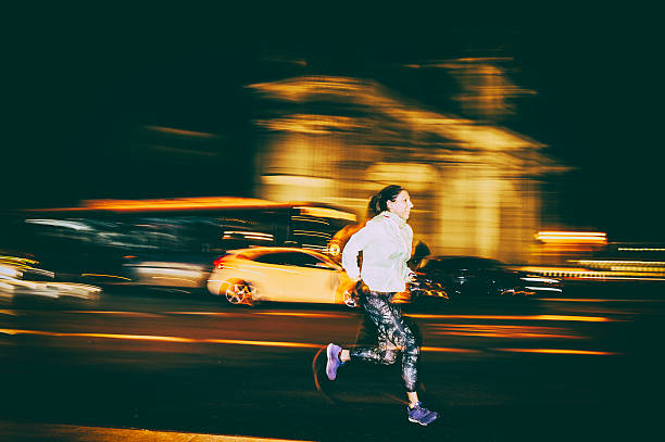 istock woman practicing running in the city at night 610231420