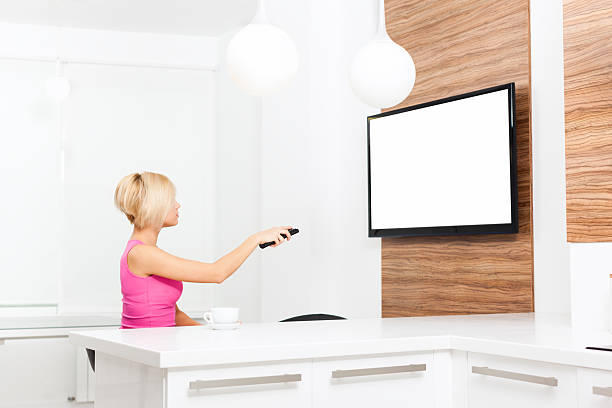 istock woman watching tv hold remote control 610232504