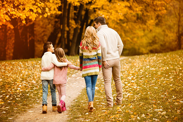 istock Family walking in autumn park 610236056