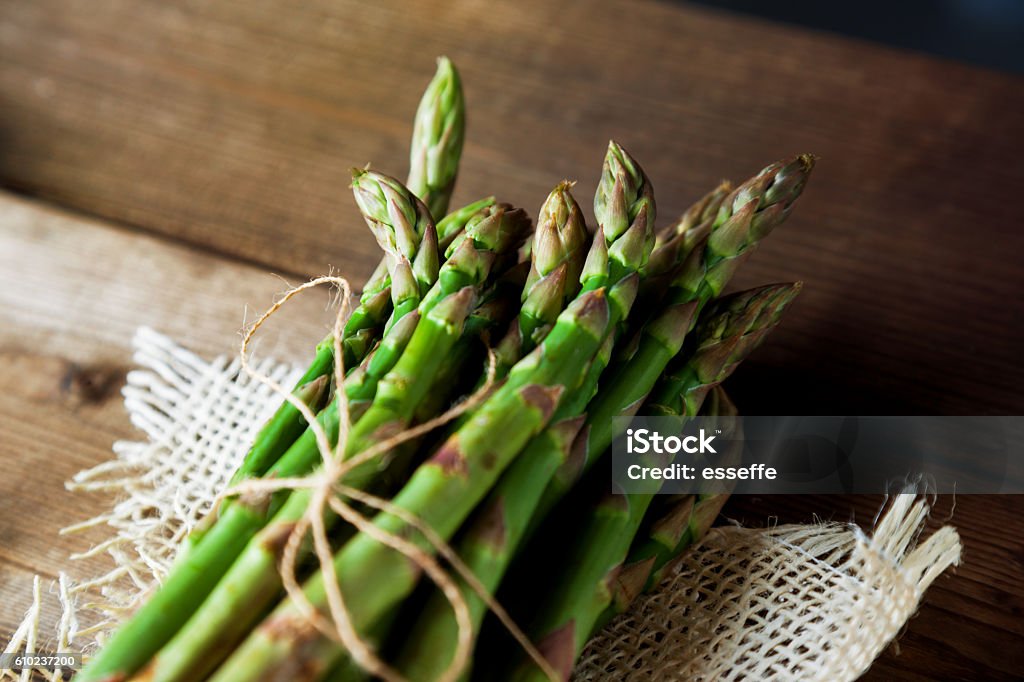 Bunch of Asparagus Delicious asparagus fresh on the wooden kitchen table ready to be cooked Recipe Stock Photo