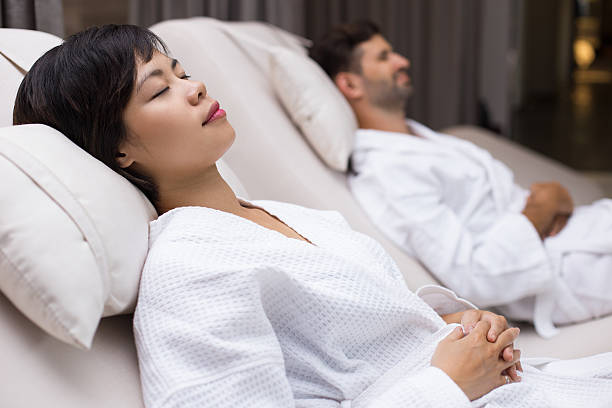istock Dozing woman and man lying on deckchairs in spa 610239610