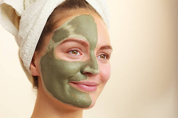 istock Woman face with green clay mud mask 610242484