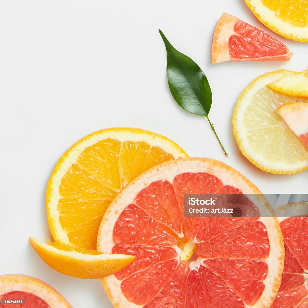 Close up of fresh citrus slices and leaf Close up of fresh citrus slices with leaf on white background Grapefruit Stock Photo