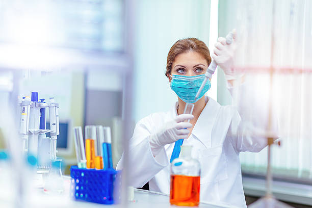 istock Woman researcher examining liquids and solutions in laboratory 610244246