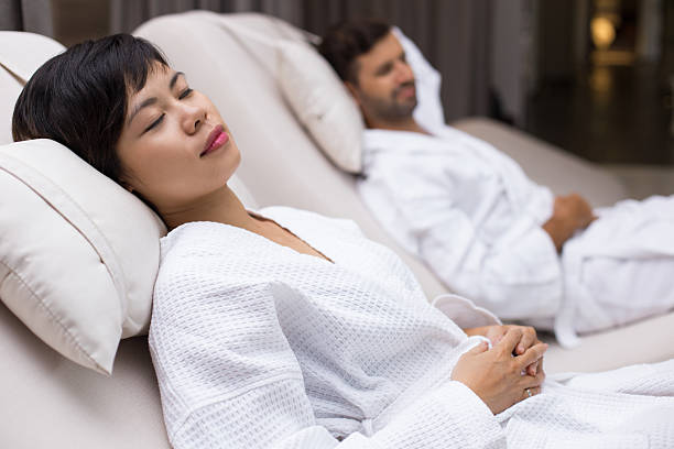 istock Man and woman dozing on deckchairs in spa salon 610245544