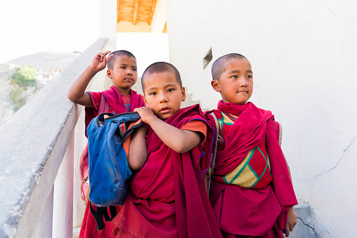 Diskit, India - August 20, 2015: Three young monks leaving Diskit monastery school. The school has computer facilities and teaches science subjects, in English, to Tibetan children of the region.