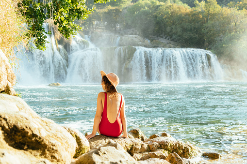Young Caucasian woman near the waterfall in Krka National Park, Croatia
