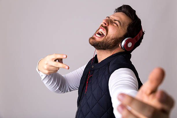 istock Young bearded man listening to music and dancing 610250026