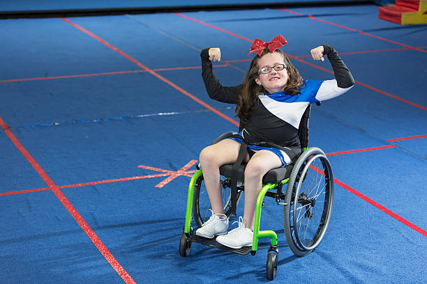 jeune fille en uniforme de cheerleading en fauteuil roulant - disabled teenager adolescence physical impairment photos et images de collection