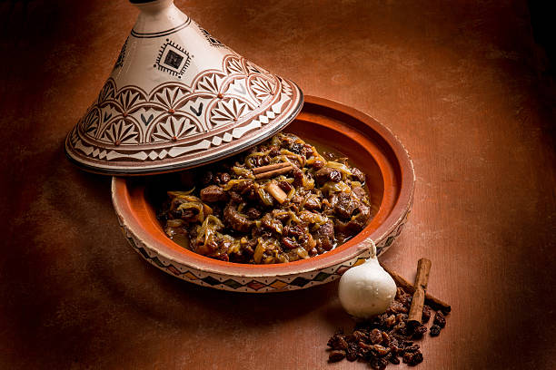tajine with meat, onion, dried grape and cinnamon traditional tajine with meat, onion, dried grape and cinnamon tajine stock pictures, royalty-free photos & images