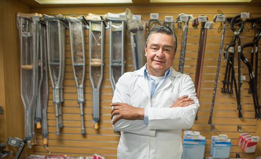 Happy man selling orthopedics equipment like crutches and walking sticks and looking at the camera smiling
