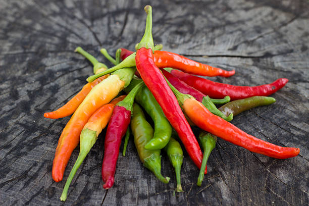 istock Chili peppers on wooden background 610254942