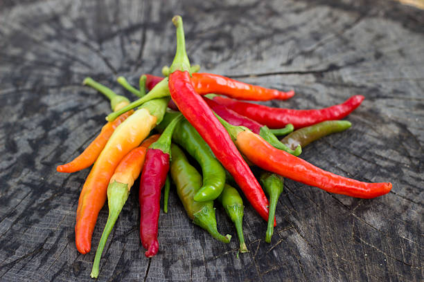 istock Chili peppers on wooden background 610255000