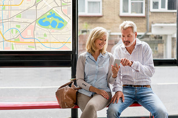 Couple using cell phone app at a bus station