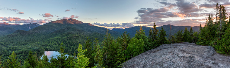A sunset panoramic view from the summit of Mount Jo, overlooking Heart Lake, Mt. Colden, and Algonquin and Wright Peaks in the High Peaks region of the Adirondack Mountains near Lake Placid, NY