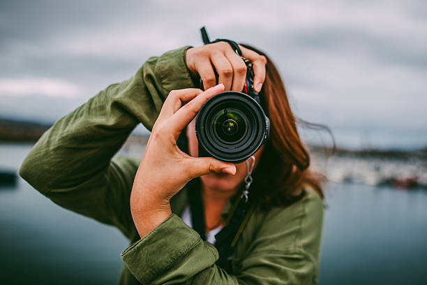 mujer joven usando cámara réflex digital - hacer fotos fotografías e imágenes de stock