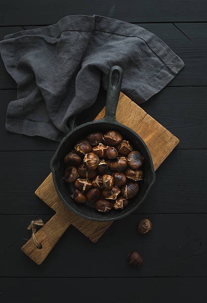istock Roasted chestnuts in iron skillet pan 610262936