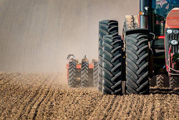 Tractor field works The tractor working on the brown field agricultural machinery stock pictures, royalty-free photos & images
