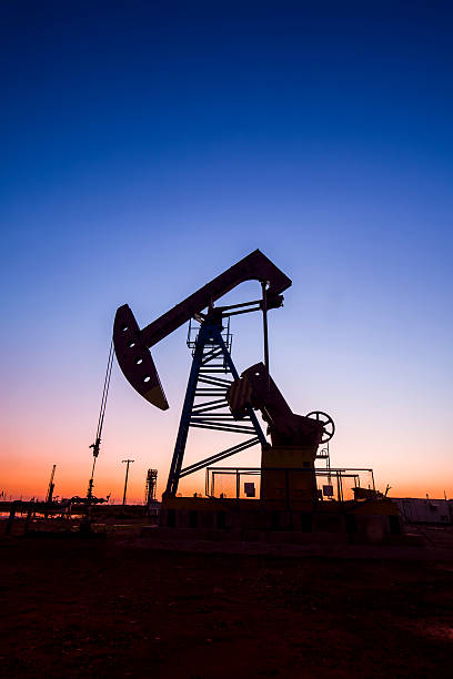 istock the evening of beam pumping unit in silhouette 610264488