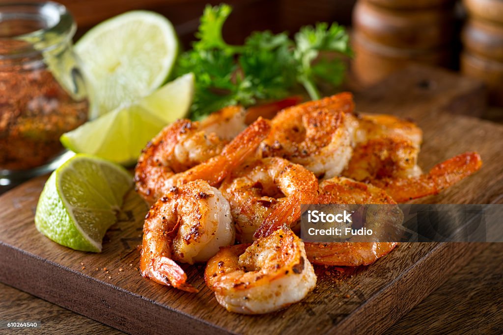 Cajun Shrimp Delicious sauteed shrimp with cajun seasoning and lime on a maple plank. Shrimp - Seafood Stock Photo