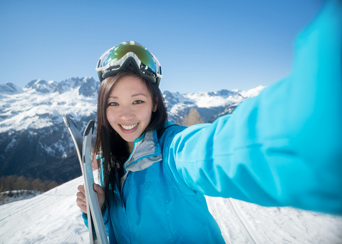Happy woman skiing and smiling while taking a selfie - winter sports concepts
