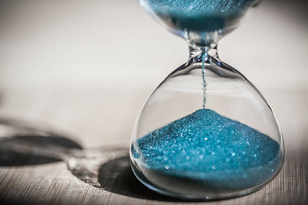 istock Sand running through the bulbs of an hourglass 610407616