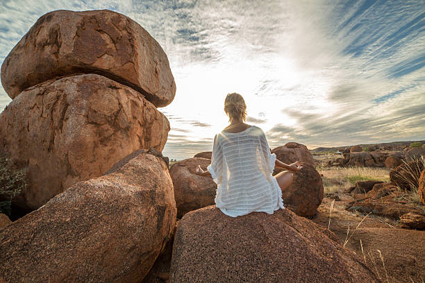 istock Female on boulder exercises yoga at sunset 610407656