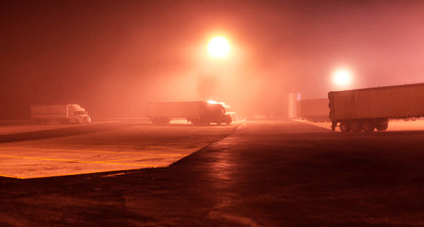 istock Foggy Nighttime Expressway Rest Stop Semi Trailer Trucks 610409678
