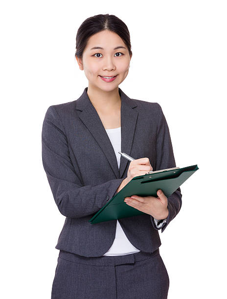 istock Businesswoman writing on clipboard 610412436